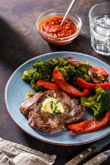 Grilled Beef steak with garlic butter and vegetables. Meat with grilled bell pepper, broccoli and onions.