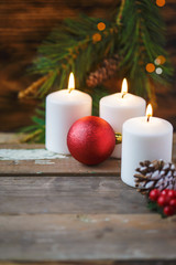 Christmas decorations, burning candles, spruce on a wooden background. New Year's concept. Postcard