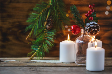 Christmas decorations, burning candles, spruce on a wooden background. New Year's concept. Postcard