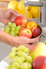 MAN WASHING FRESH FRUIT IN COLLANDER