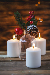 Christmas decorations, burning candles, spruce on a wooden background. New Year's concept. Postcard