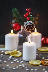 Christmas decorations, burning candles, candy ,citrus, spruce on a wooden background. New Year's concept. Postcard
