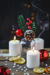 Christmas decorations, burning candles, candy ,citrus, spruce on a wooden background. New Year's concept. Postcard