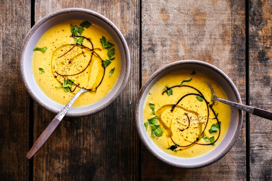 Two bowls of creamy and colorful soup