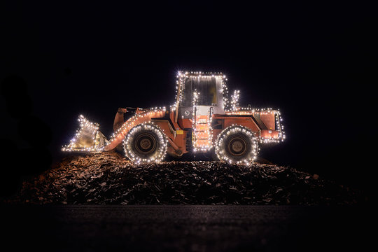 Blurred wheel loader decorated with lights in winter