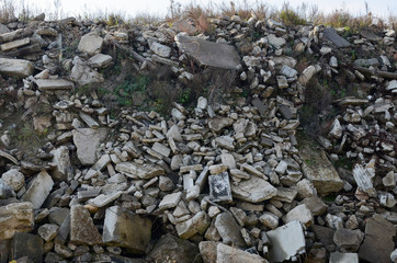 Construction waste, reinforced concrete blocks and rusty fittings.  Building debris. Ecology, globalization. Concrete slabs, dump. Garbage