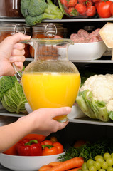TAKING JUG OF FRESH ORANGE JUICE FROM REFRIGERATOR