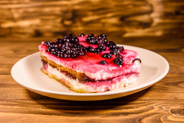 Ceramic plate with cheesecake on wooden table