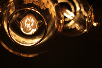 classic edison bulb in a transparent glass ceiling on a black background