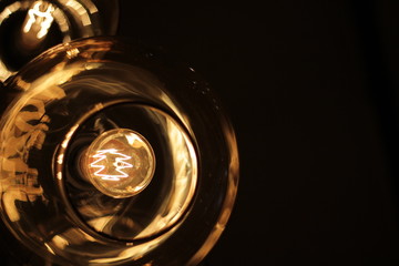 classic edison bulb in a transparent glass ceiling on a black background