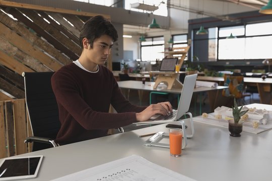Male architect working on laptop in office