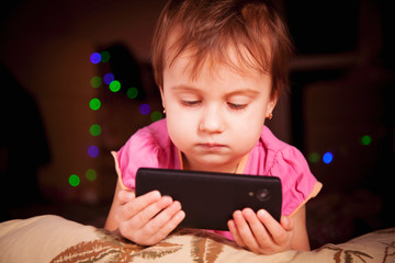 Social Media addiction. Little child girl holding smart phone (psychological problems, media mania, education concept)