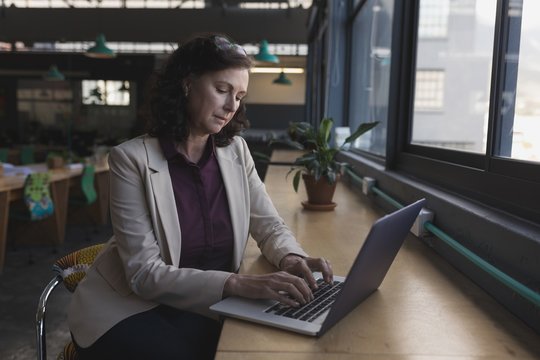 Businesswoman working on laptop at table