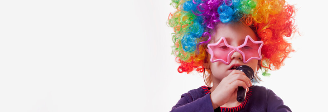 The famous actress. Humorous portrait of cute child girl singing with a microphone. Happy childhood, teaching singing, music, child development concept.