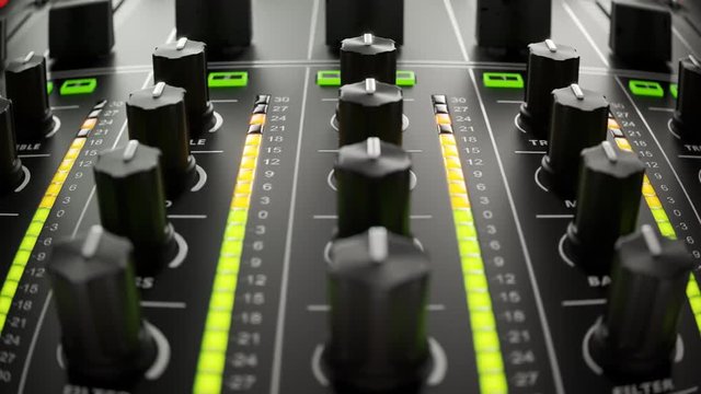 Close-up of an audio mixing console with faders and LED meters