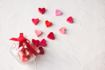 Valentine's day concept. jar with hearts of sweets on a light background, top view.selective focus