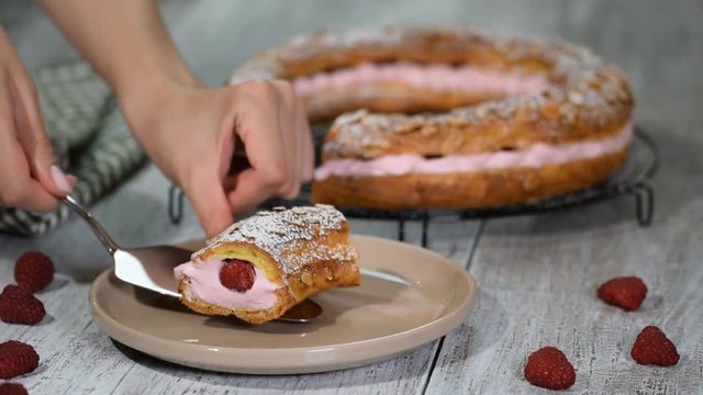 Homemade choux pastry cake Paris Brest with raspberries, almond, sugar powder. French dessert.