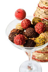  Close up of perfect dessert  - chocolate truffles with creamy filling,  raspberry and chocolate crisps in glass cup izolated on white.  Christmas background.