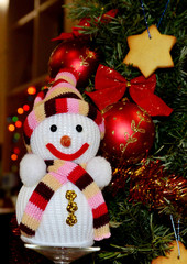 Christmas tree decorated with red balls, traditional ginger biscuits, toy snowman and shiny tinsel