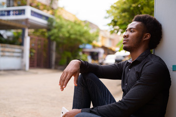 Young handsome African businessman in the streets outdoors
