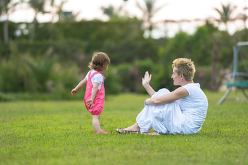 Naklejka premium mother and little daughter playing at backyard