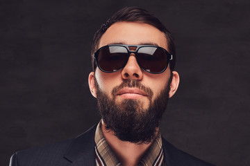 Obraz premium Close-up portrait of a bearded man wearing a suit and sunglasses.