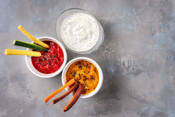 Top view of dips with coroful vegetable sticks