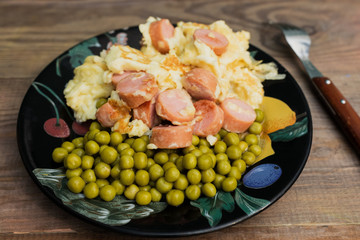 Fried eggs on a plate with sausages and peas