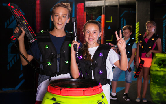 Girl and boy with laser guns on lasertag arena