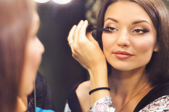 Beautiful sexy woman wearing makeup looking in the mirror