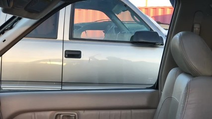 Hammer breaks glass in slow motion on luxury car before theft; in angled lighting. - Powered by Adobe