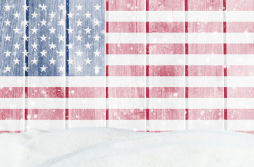 Christmas winter background with wooden wall, falling snow, snowdrift and American flag