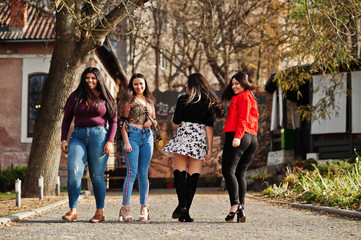 Naklejka premium Group of four happy and pretty latino girls from Ecuador posed at street.