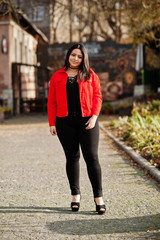 Pretty latino model girl from Ecuador wear on black and red jacket posed at street.
