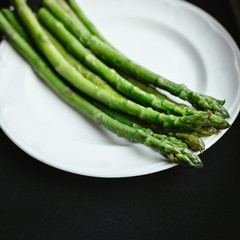 boild green asparagus on the white plate