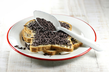 Dutch white bread with hagelslag (chocolate sprinkles) topping on enamel plate