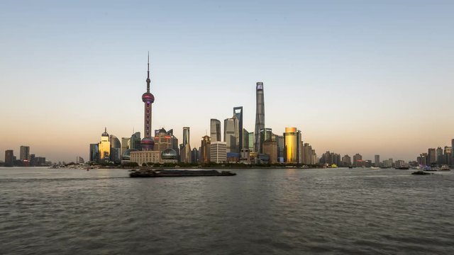Time Lapse - Day to night - Shanghai the Bund with a view above the river and the transportation by big ships