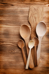 Top view of pile of wooden spoons on wooden background