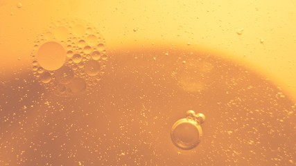 Yellow bubbles and drops of oil and water, beer and beverage texture background.