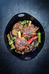 Traditionelle gegrillte Lammhaxe mit Aubergine und Chili als Draufsicht in einem Modern Design...