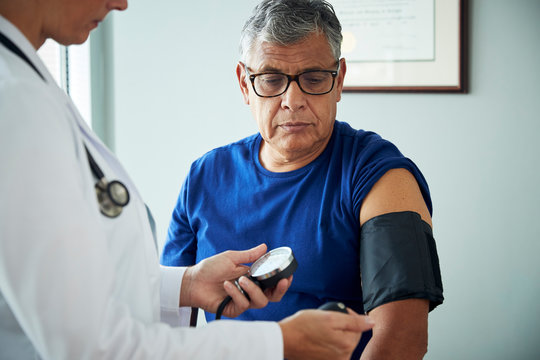 Doctor taking man's blood pressure