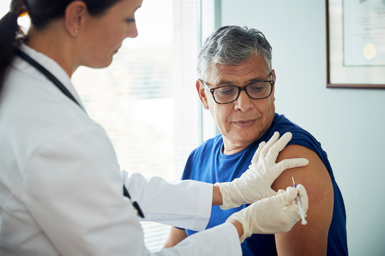 Doctor administering shot to man