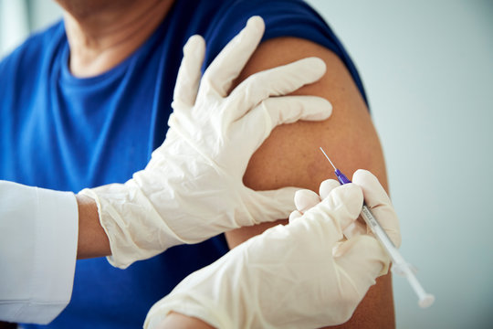 Doctor administering shot to man
