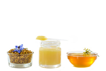 variety of raw organic honey bee products board surrounded by flowers on white background