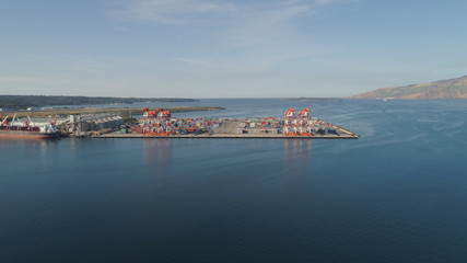 Fototapeta na wymiar Sea cargo port with cranes, docks, containers in Subic Bay. Philippines,Luzon. Aerial view: cargo port and container terminal.