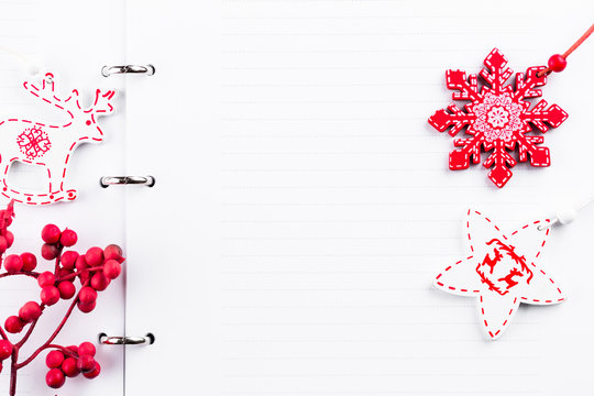 Christmas background with blank spiral notebook under Christmas tree branches, top view snowflake effect, letter to Santa or holidays planning, to do list, copy space