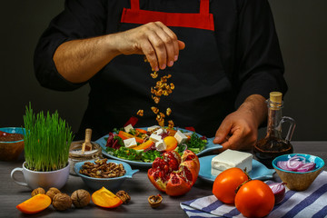 Freezer food prepare in process vegetarian salad with fruits and greens by chef hand in home kitchen. Dark black background. menu restaurant
