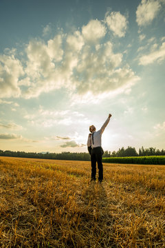 Businessman with one arm raised up high in success