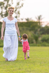 Fototapeta premium mother and little daughter playing at backyard