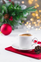 Cup of espresso or americano coffee in white cup in cozy Christmas arrangement, festive decoration with bokeh background, copy space